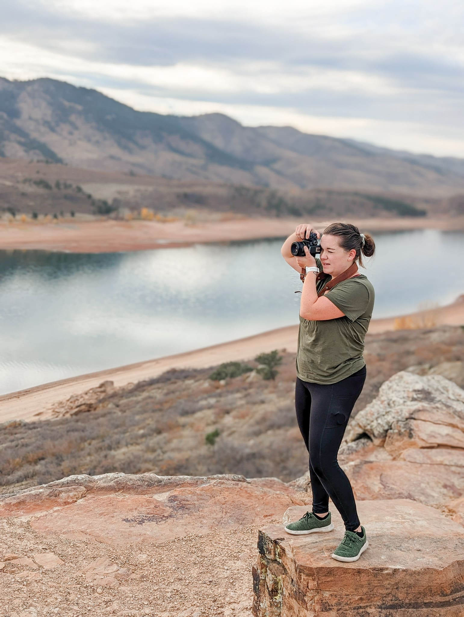 Woman with camera stands on cliff overlooking reservoir | 5 Photos Every Small Business Needs | Kayla Petrosky Photography