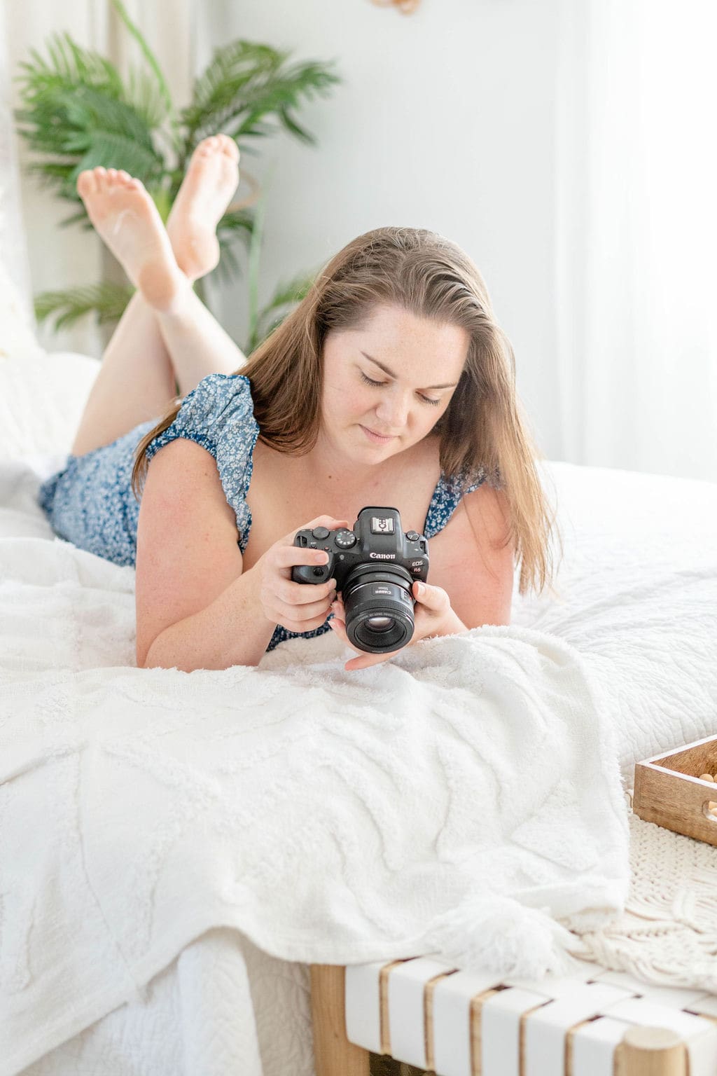 Woman lies on bed looking at screen on back of camera | Make Marketing Easier | Kayla Petrosky Photography