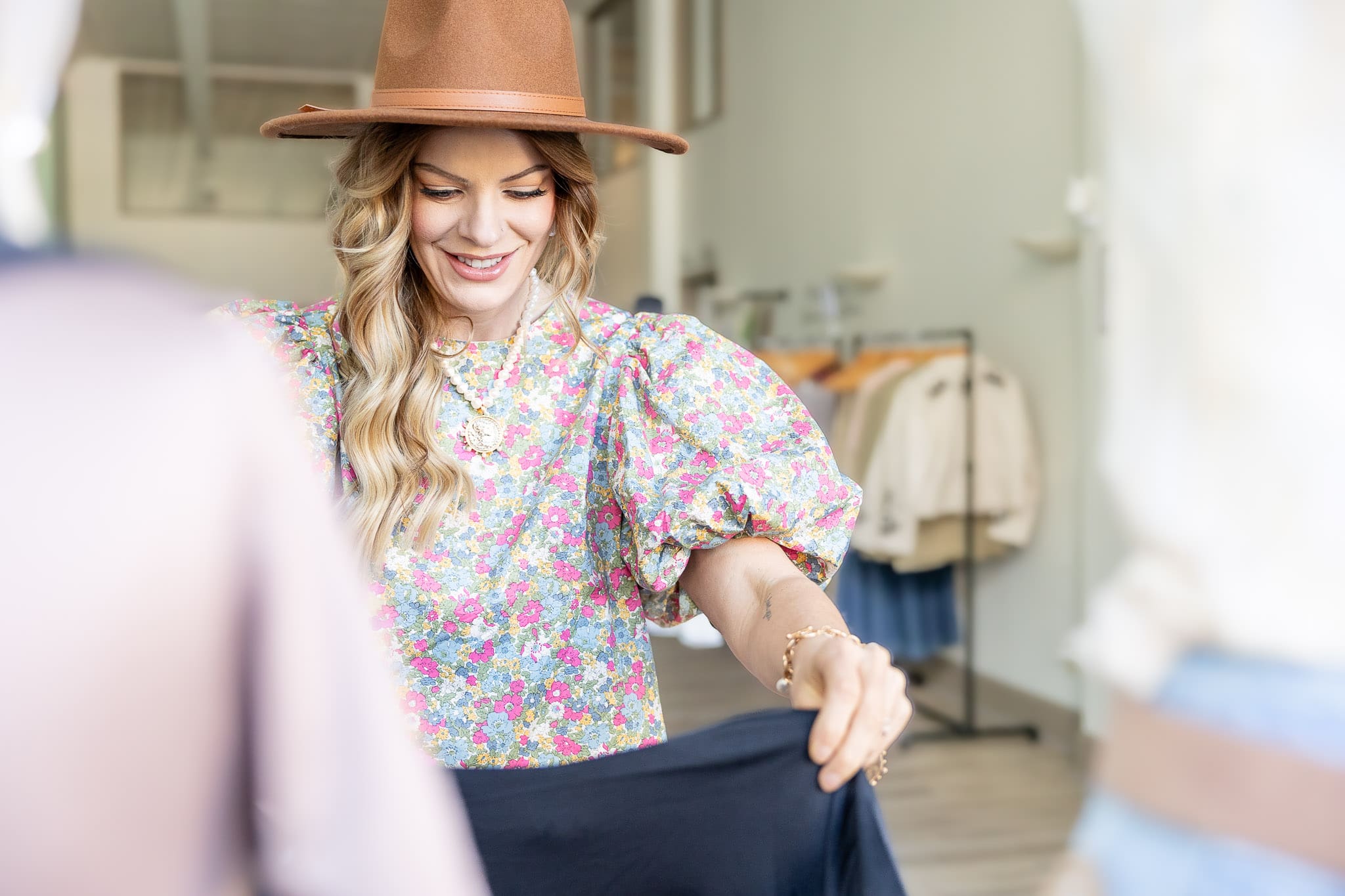 Woman folds clothes at her fashion boutique