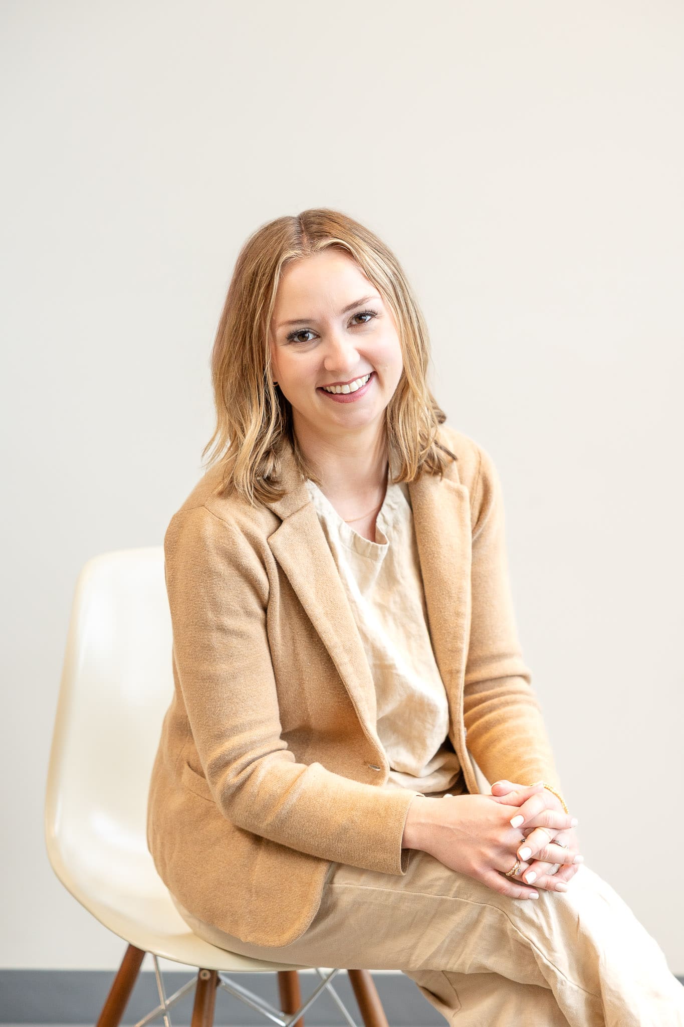 Woman in beige blazer sits on chair and smiles at camera | Brand Photo Process | Kayla Petrosky Photography