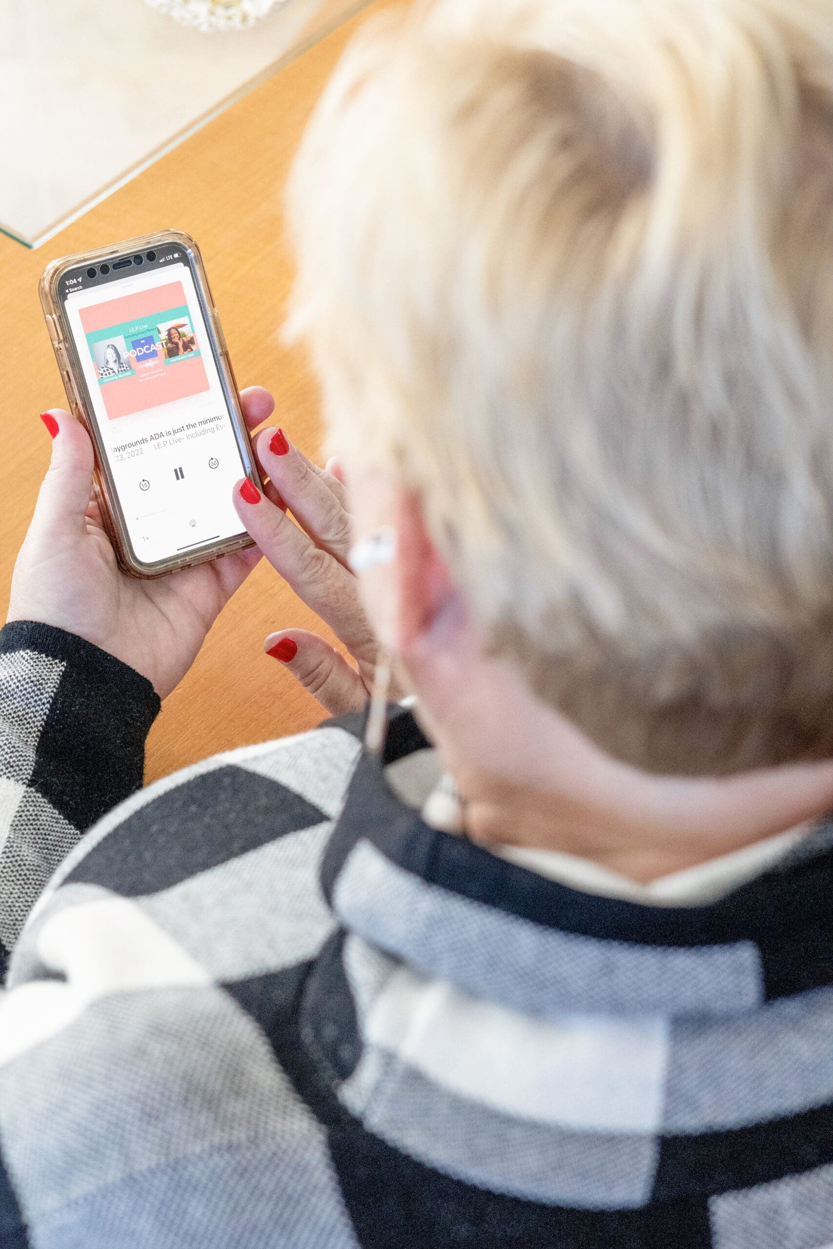 Person with red fingernails holds phone that is showing a podcast episode | Know your ideal client before brand photos | Kayla Petrosky Photography
