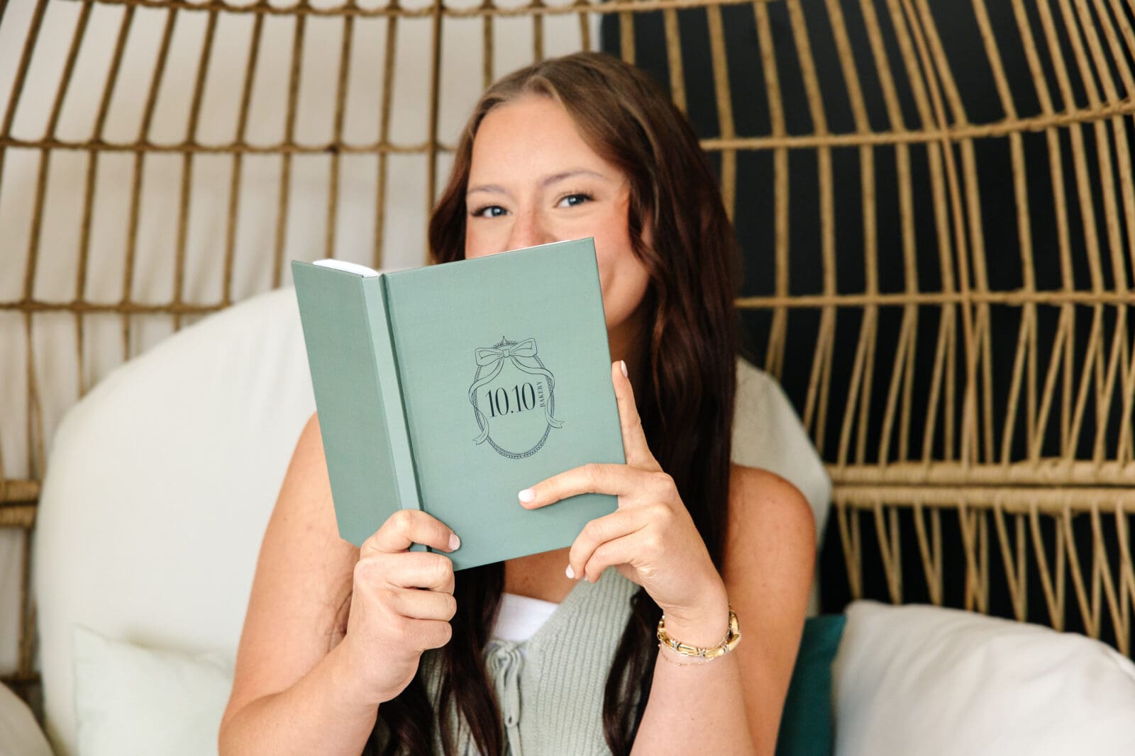 Woman hides behind book with 10.10 Bakery logo on front | Bakery Brand Photos | Kayla Petrosky Photography