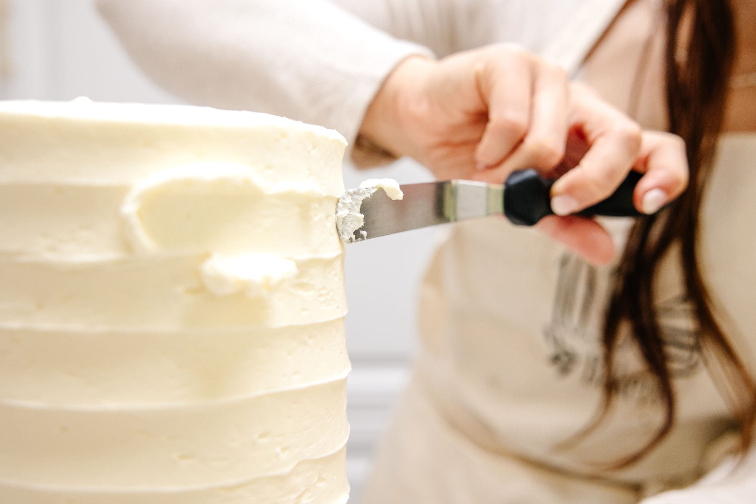 Person puts icing on cake | Bakery Brand Photos | Kayla Petrosky Photography